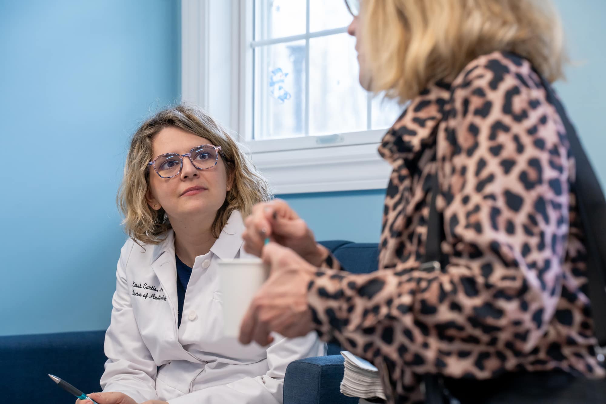 Dr. Sarah Curtis, Doctor of Audiology, listening to a patient during a tinnitus consultation in Concord Township