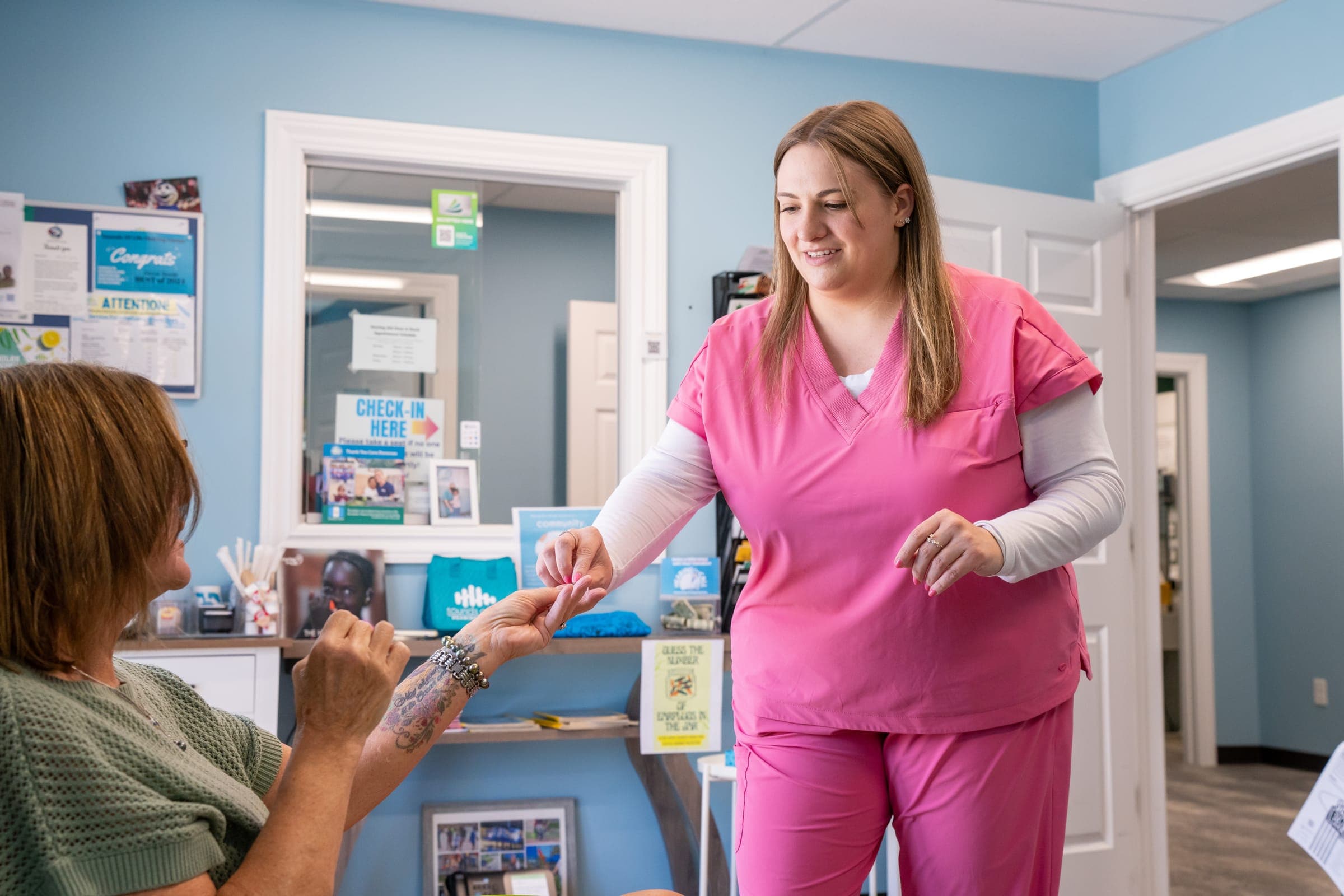 Audiologist handing a hearing aid to a patient