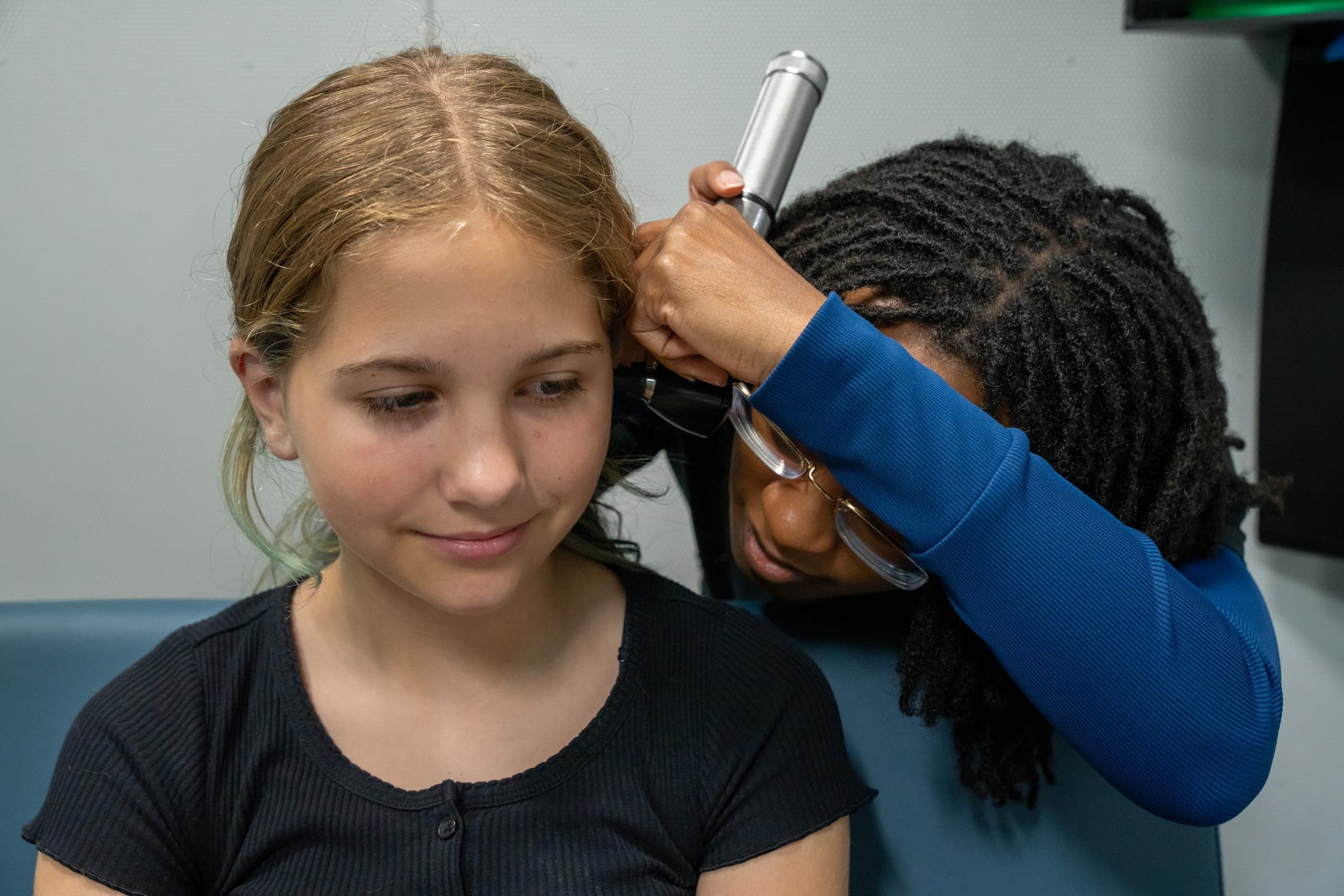 Audiologist examining a patient’s ear with an otoscope